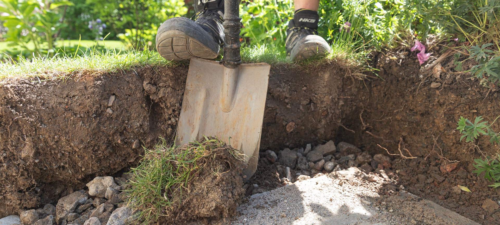 Bildausschnitt zeigt einen Garten- und Landschaftsbauer, bei den Vorbereitungen zum Terrassenbau