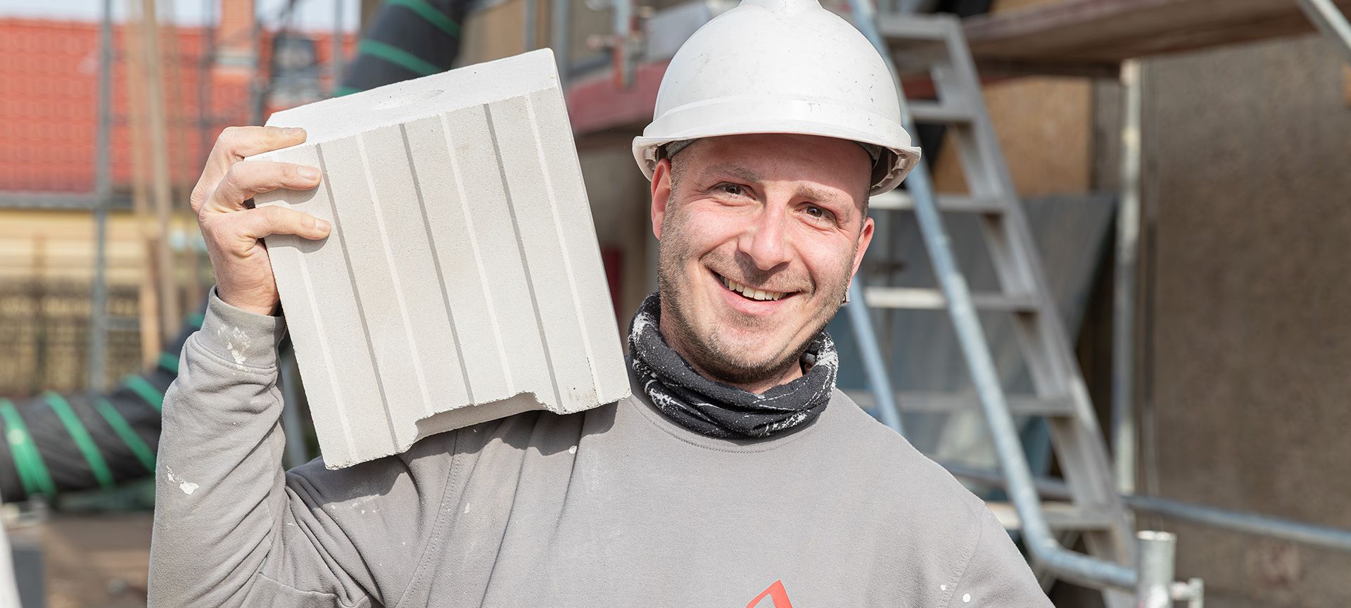 Bauhandwerker mit Blockziegel bei der Sanierung eines Mehrfamilienhauses